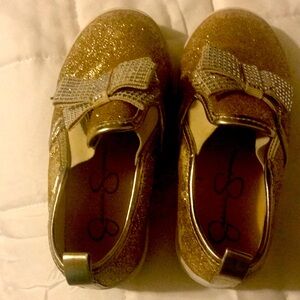 Girls slip on gold glitter shoes.